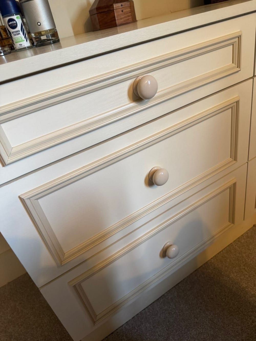 After cleaning: cream panelled bedroom drawers with ceramic knobs